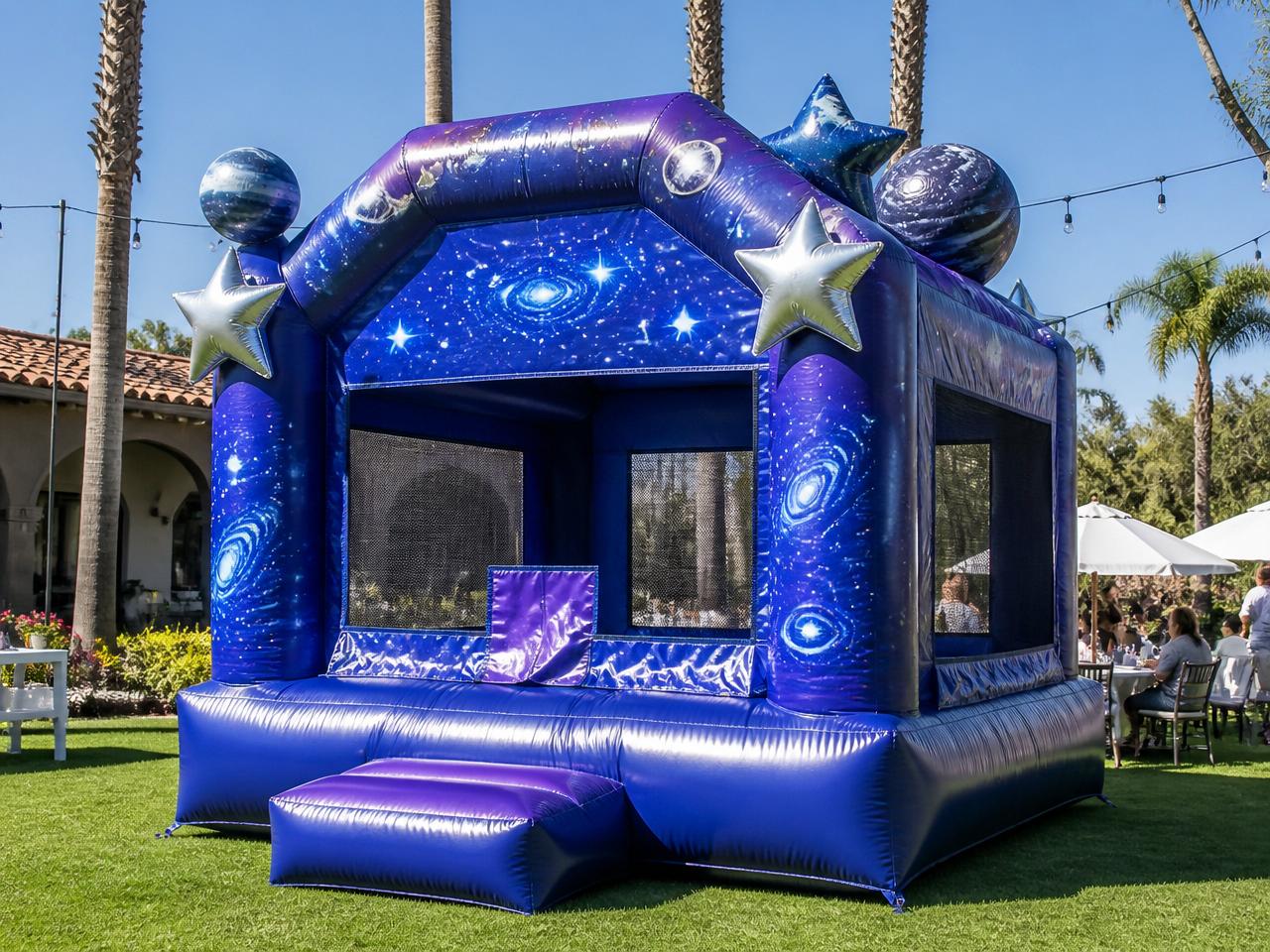 Galaxy-themed bounce house set up on a lawn at a party